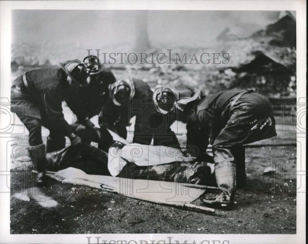 1951 Press Photo Chicago firemen &amp; injured at 5 alarm blaze at warehouse - Historic Images