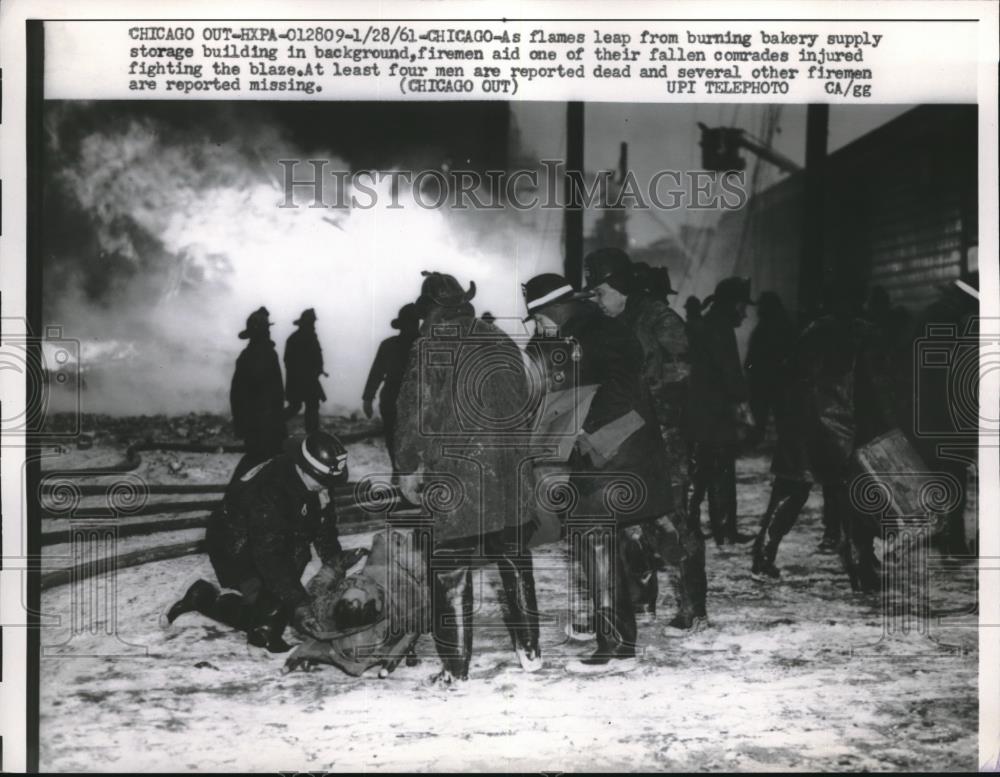 1961 Press Photo firemen tending to a wounded comrade during fire - neb89907 - Historic Images