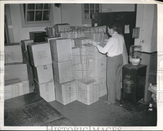 1945 Press Photo Detective examines part of the loot at the Safe & Loft Squad HQ - Historic Images