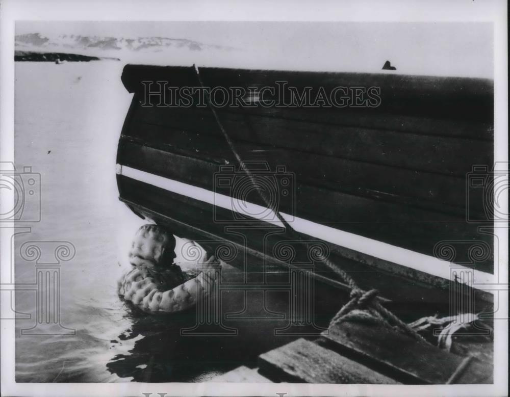 1954 Press Photo Britannia Lake, Greenland diver Corp Sanders repairs boat - Historic Images