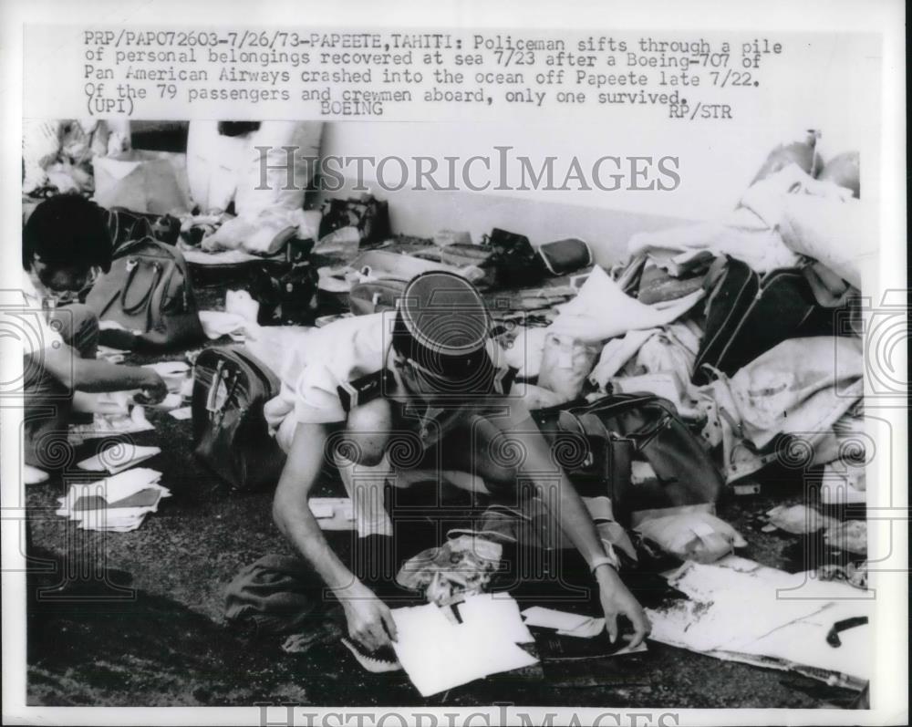 1973 Press Photo Policeman In tahiti Sifts through Belongings after Boeing 707 - Historic Images