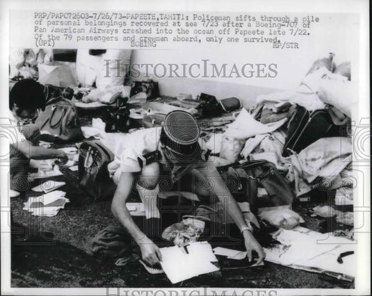 1973 Press Photo Policeman In tahiti Sifts through Belongings after Boeing 707 - Historic Images