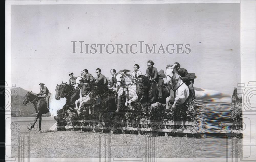 1934 Press Photo Ten Equestrians On Horses Jump Them Over A Fence At Same Time - Historic Images