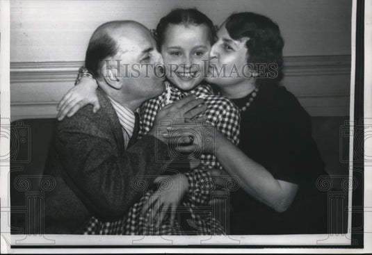 1958 Press Photo Dr. Jerzy Nowinski and wife Maria kiss daughter Christina. - Historic Images