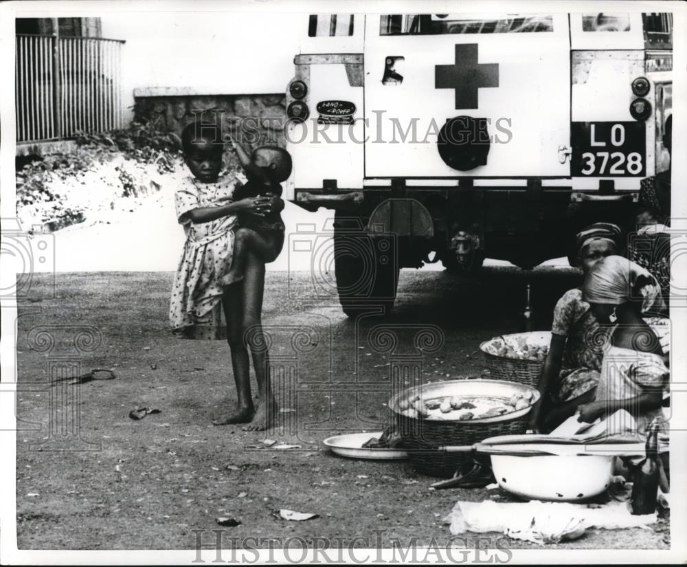 1968 Press Photo Biafran Girl Holds Child As Others Prepare Food In Yard - Historic Images