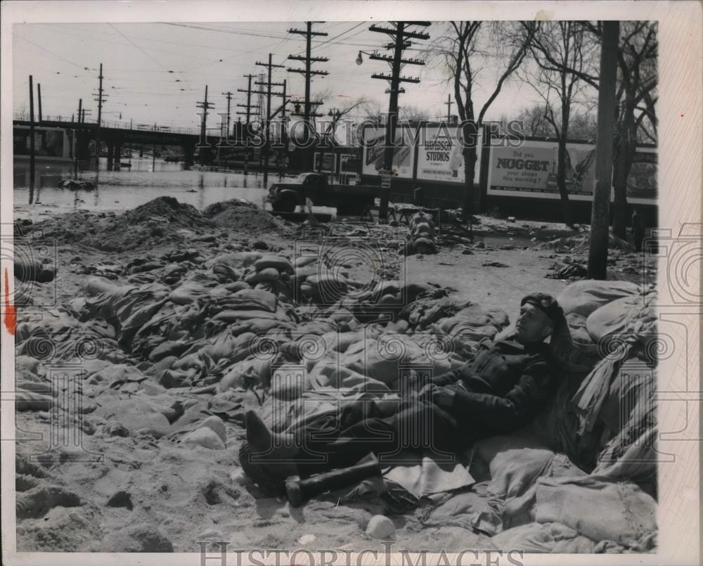 1950 Press Photo Red River flood. Winnipeg soldier removes boots. - Historic Images