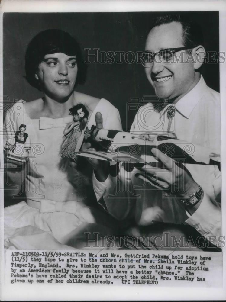 1959 Press Photo Mr. and Mrs. Gottfried Pekema holding toys for child. - Historic Images