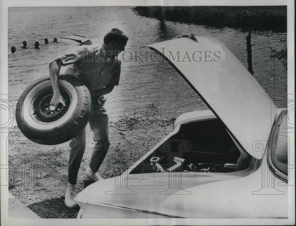 1961 Press Photo Dick Freienmuth uses spare tire to throw out as a lifesaver. - Historic Images