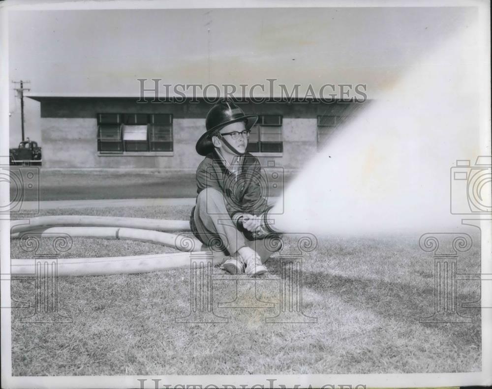 1960 Press Photo Junior fire marshall Jeffery Butt using a fire hose. - Historic Images