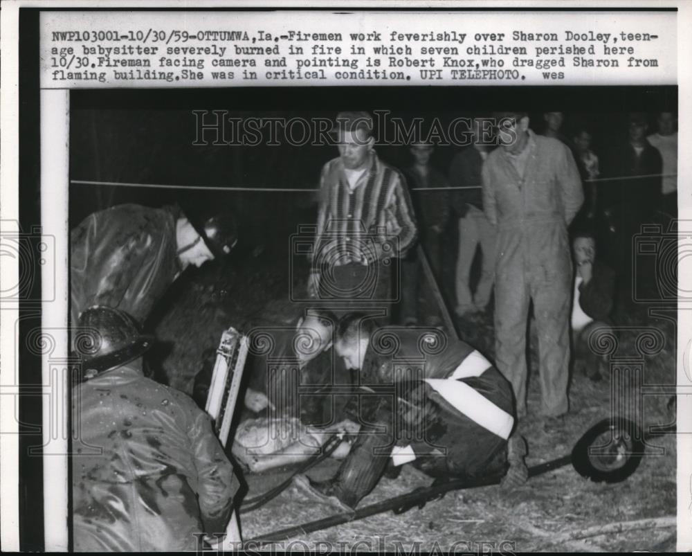 1959 Press Photo Fireman work feverishly over burned youth - nec39871 - Historic Images