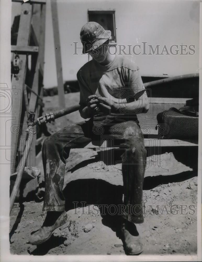 1937 Press Photo John Forrest examine a piece of Ore from the Silver Strike Area - Historic Images
