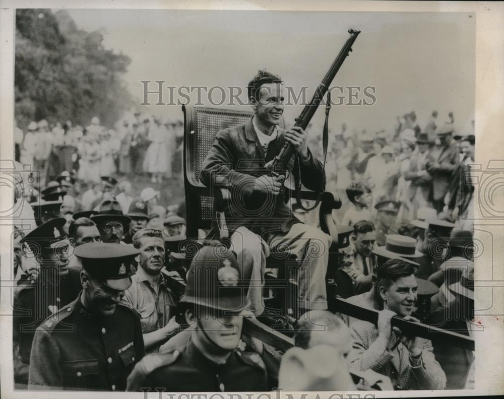 1933 Press Photo Winning Nimrod DE Woods Carried By In Chair With Rifle - Historic Images