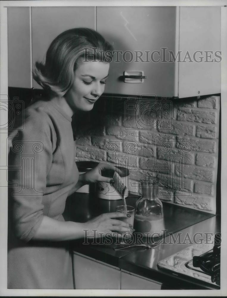 1961 Press Photo A girl putting an unflavored gelatin in a fruit juice. - Historic Images