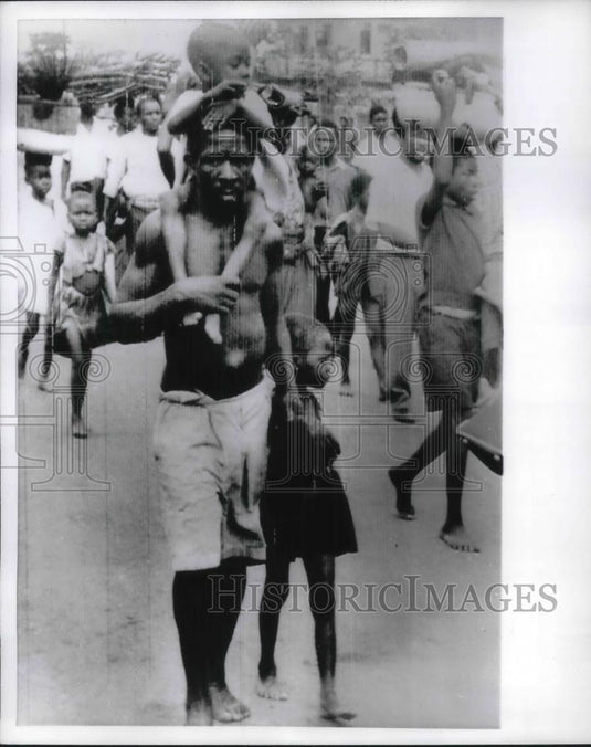 1970 Press Photo Refugee walking in a busy street. - Historic Images