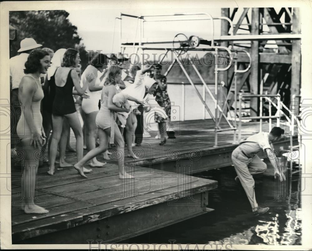 1943 Press Photo Members of Riviera Club push Bud Swain, coach, into the pool - Historic Images