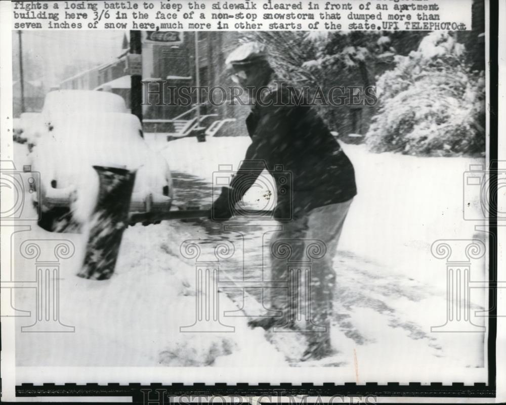 1962 Press Photo Snow storm made an icy front yard and a man tries to clear it - Historic Images