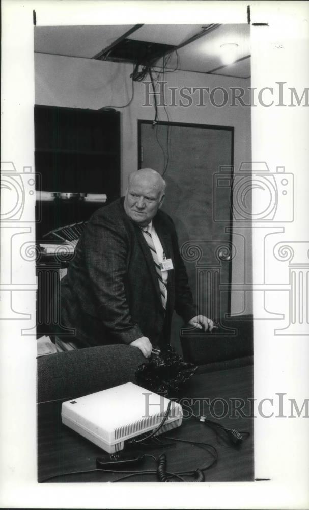 1991 Press Photo Cecil Allen stands in a hole in the CMHA ceiling, - Historic Images