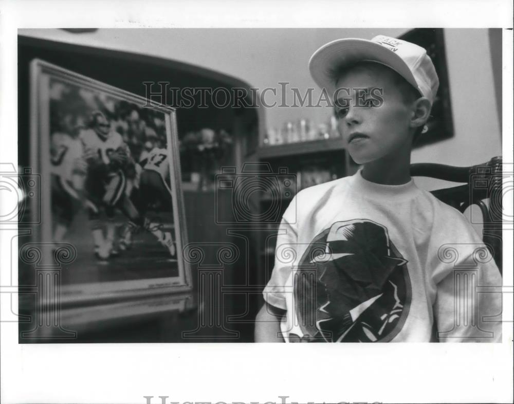 1990 Press Photo Danny Dunn with photo of 49ners quarterback Joe Montana, - Historic Images