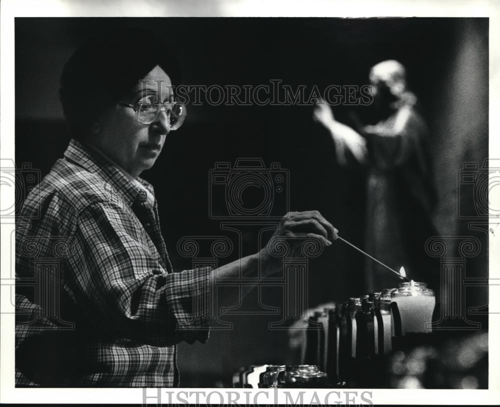 1990 Press Photo Ree Crinite Administrator Our Lady M Mt lights a candle. - Historic Images