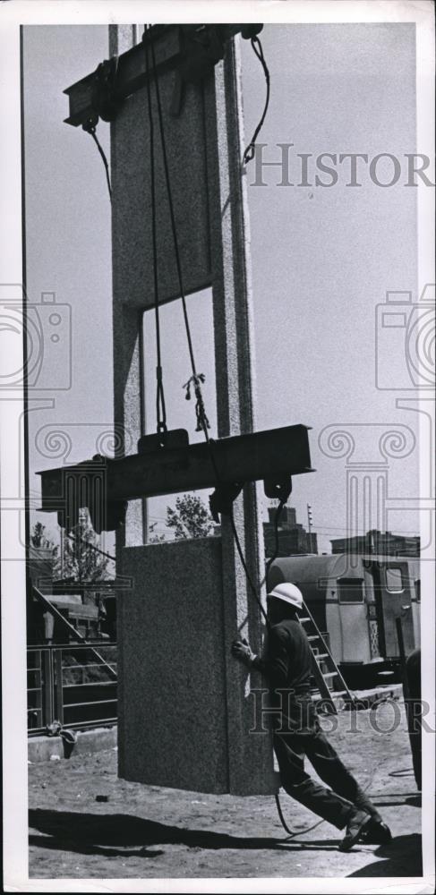 1965 Press Photo A 200 pound man pushing the 1100 pound section at the plant - Historic Images