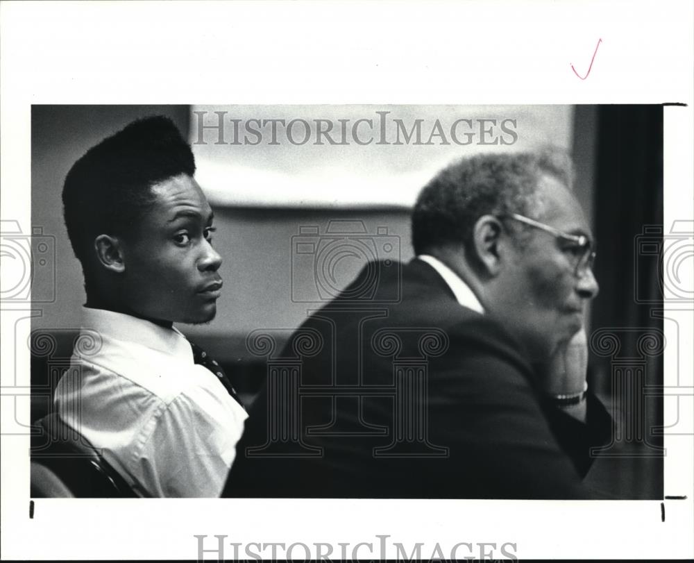 1990 Press Photo Eurgene D. Canady Jr looks over his lawyers shoulder - Historic Images