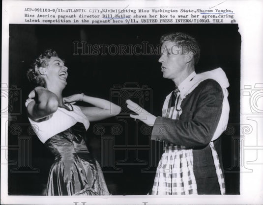1959 Press Photo Bill Butler showing Sharon Vaughn how to wear an apron - Historic Images