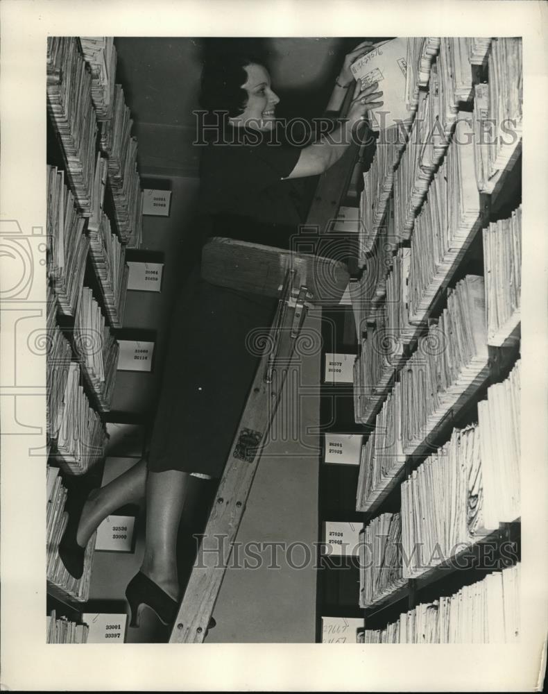 1932 Press Photo Using a ladder to reach documents that are 12 feet high. - Historic Images