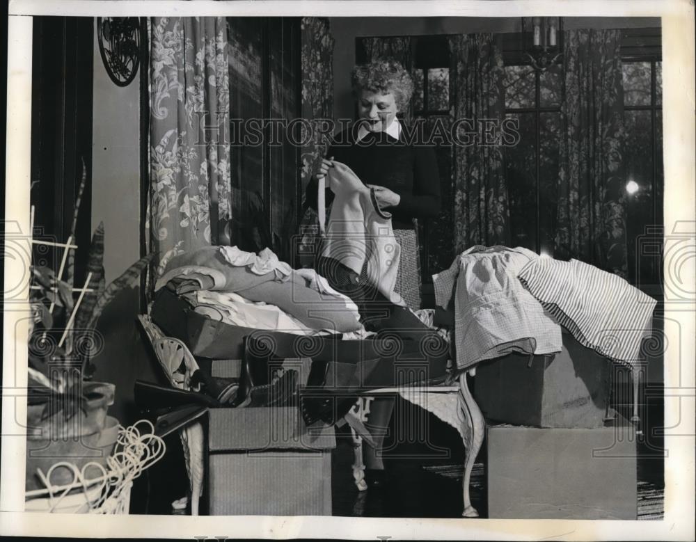 1942 Press Photo Mrs. Nelson sorting her children&#39;s clothing and bedding for - Historic Images