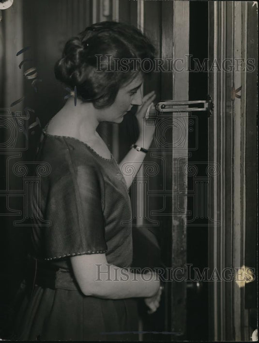 1921 Press Photo Woman demonstrates home safety lock boalt on a door - Historic Images