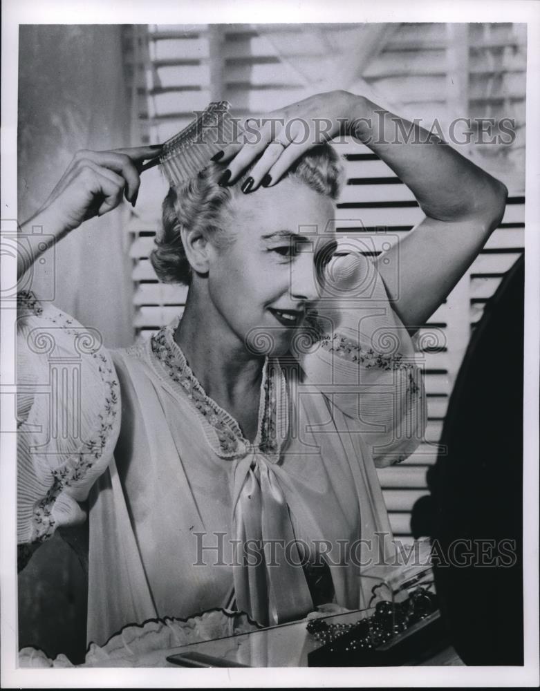 1956 Press Photo Mature Woman brushes her hair. - Historic Images