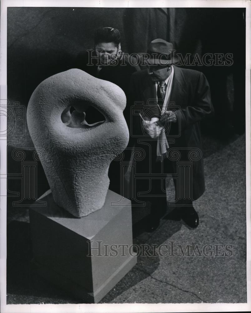 1952 Press Photo A couple looking at a stone figure, while a man cleans off his - Historic Images