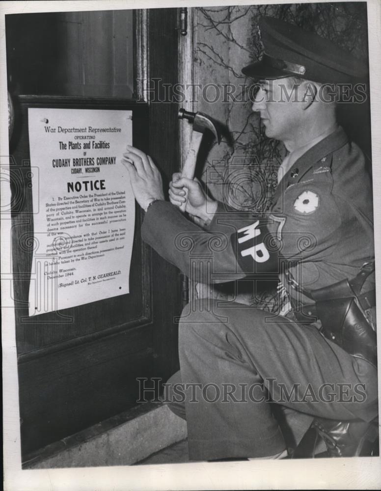 1944 Press Photo PFC Virgil Duncan tacks notice at Cudahy Bros Packing Plant - Historic Images