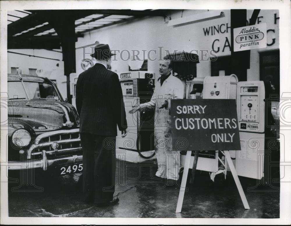 1956 Press Photo Service station attendant explains oil consumption cut back - Historic Images