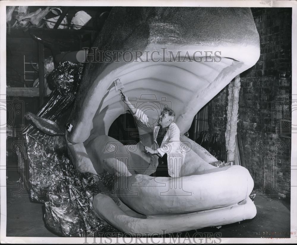 1955 Press Photo George Sprunk pictured while painting a whale statue - Historic Images