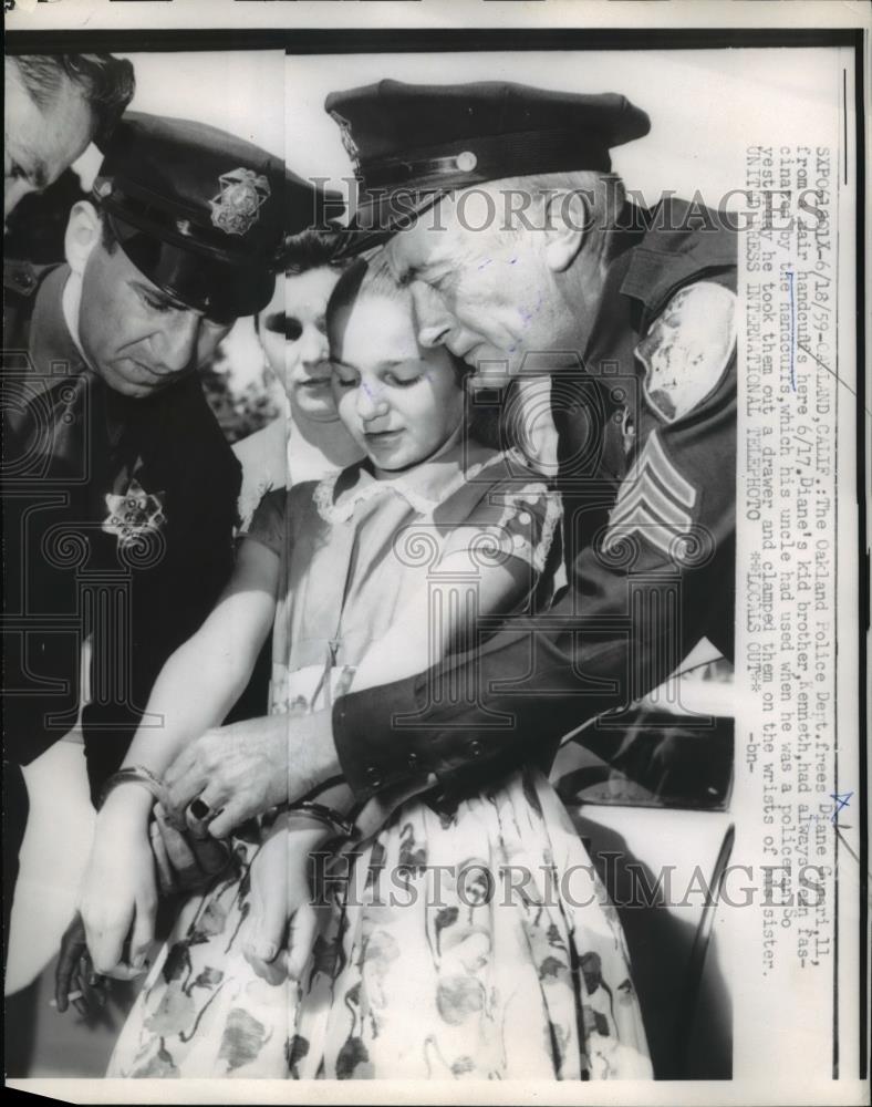 1959 Press Photo Oakland Police Dept frees Diane Gunari, 11 from a pair of - Historic Images