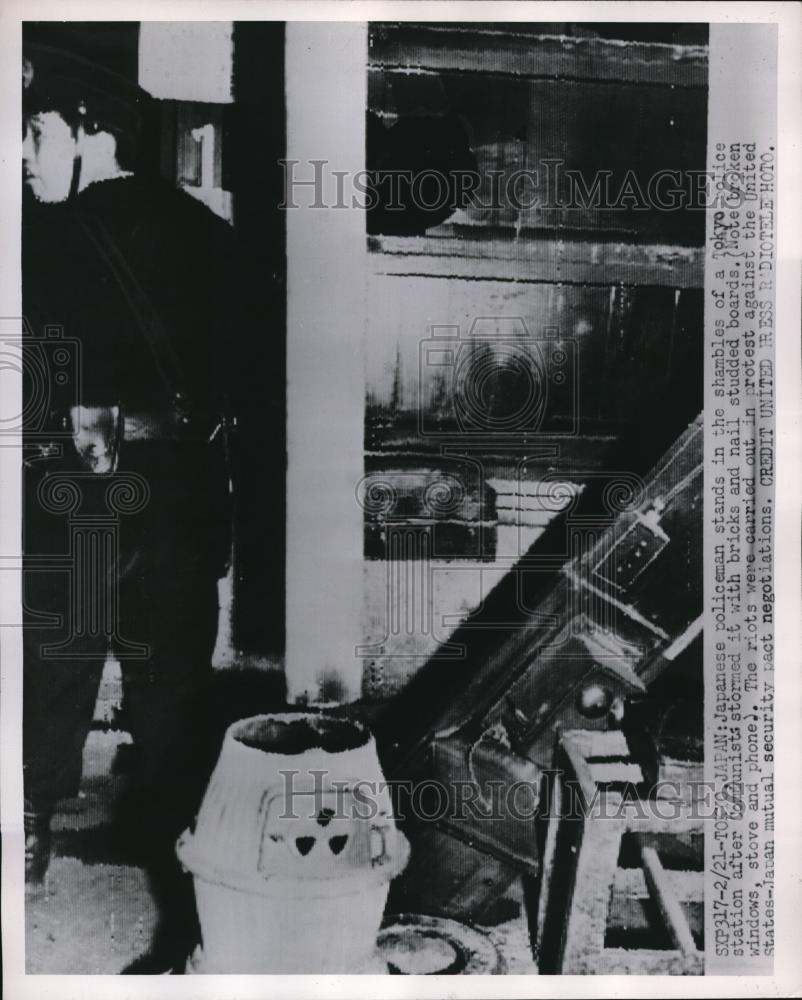 1952 Press Photo Tokyo Japanese policeman stands in shambles of police station - Historic Images