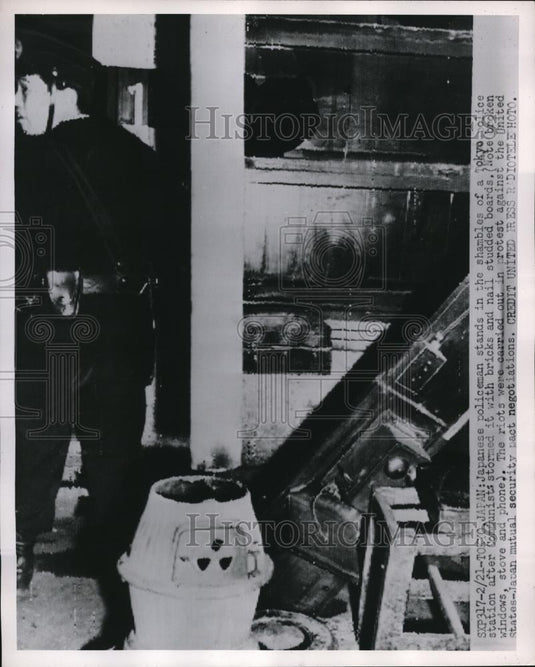 1952 Press Photo Tokyo Japanese policeman stands in shambles of police station - Historic Images