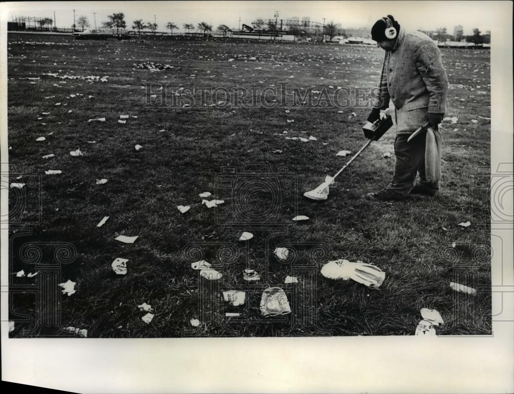 1961 Press Photo Man collecting garbage on the field - Historic Images