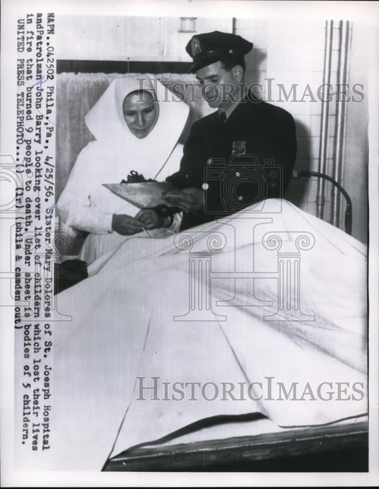 1956 Press Photo Sister Mary Dolores looked over list of children died in fire. - Historic Images