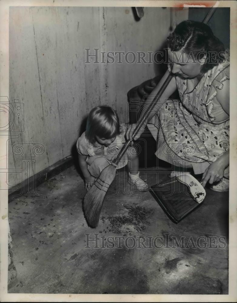 1951 Press Photo Isabel Lukaszeweki sweeps crickets as child Diana looks on - Historic Images