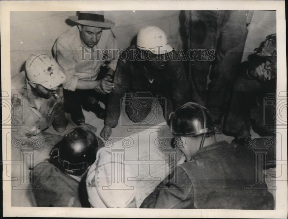 Mine workers mapping a rescue of sixty four miners. - Historic Images