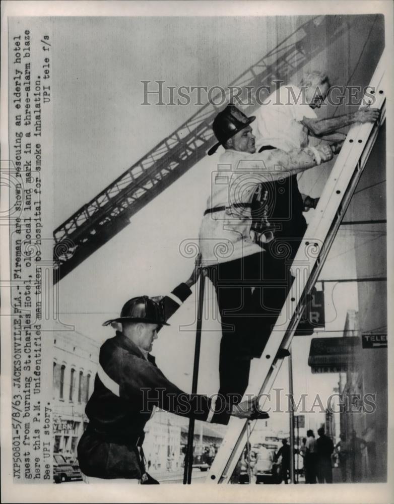 1963 Press Photo Fireman rescue elderly from burning St Charles Hotel - Historic Images