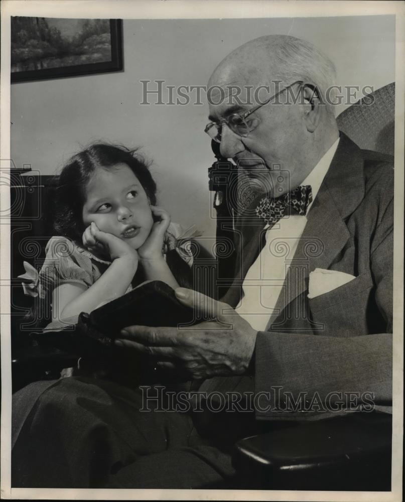 1947 Press Photo Elderly man reads the bible to a small girl. - Historic Images