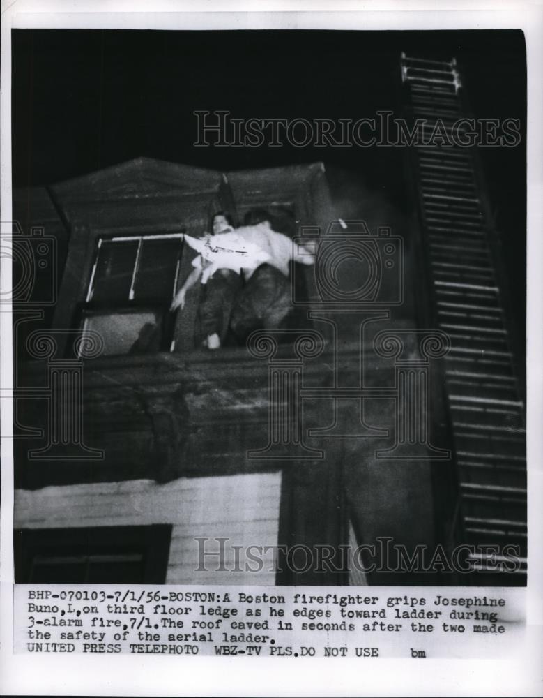 1956 Press Photo Boston Fire fighter grips Josephine BUno during 3-alarm fire. - Historic Images