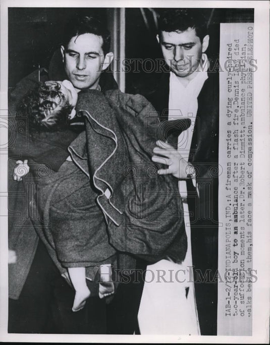 1953 Press Photo Fireman carries the critical little boy to an ambulance - Historic Images