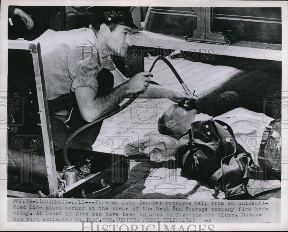 1952 Press Photo Fireman John Baumber receiving help from a life squad worker - Historic Images