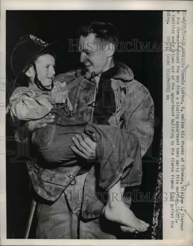 1951 Press Photo Dennis Loftus smiles as he thanks fireman William L Sherman - Historic Images