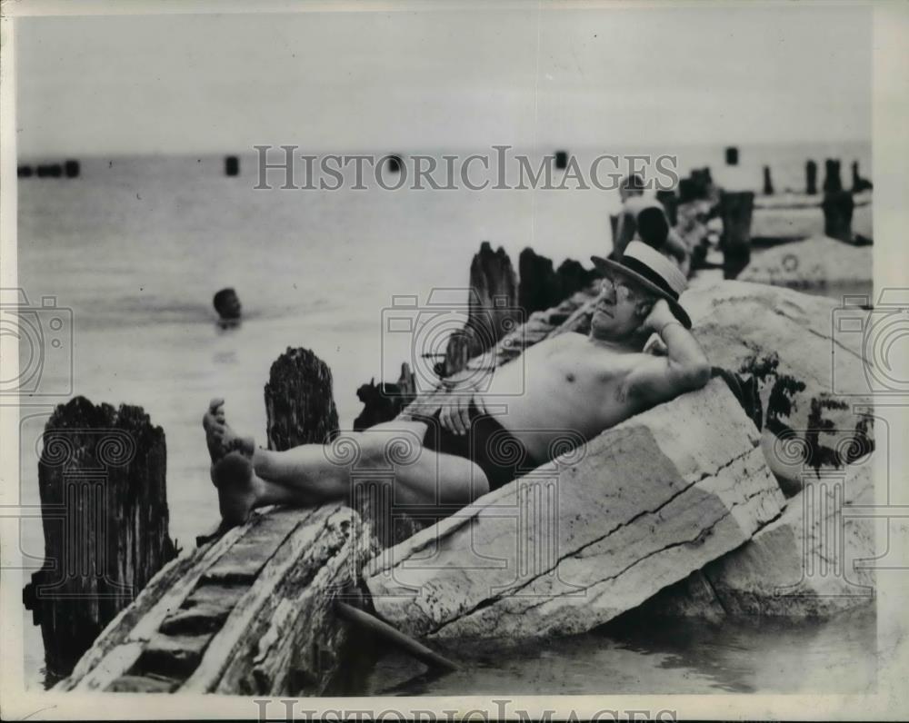 1947 Press Photo The man blissfully wriggling at the Chicago's summer sun - Historic Images