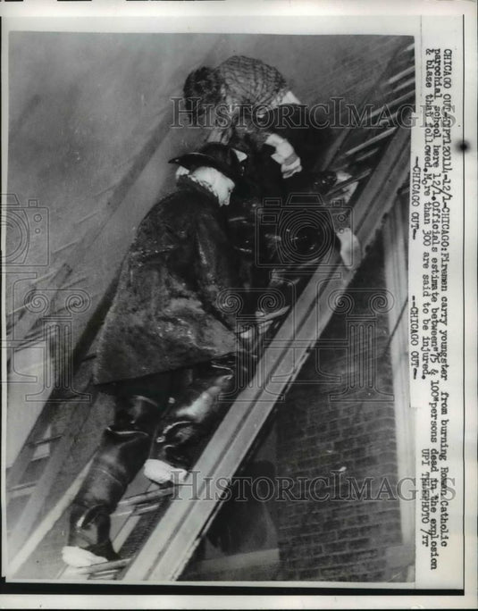 1958 Press Photo Fireman carry youngster from burning Roman Catholic school - Historic Images