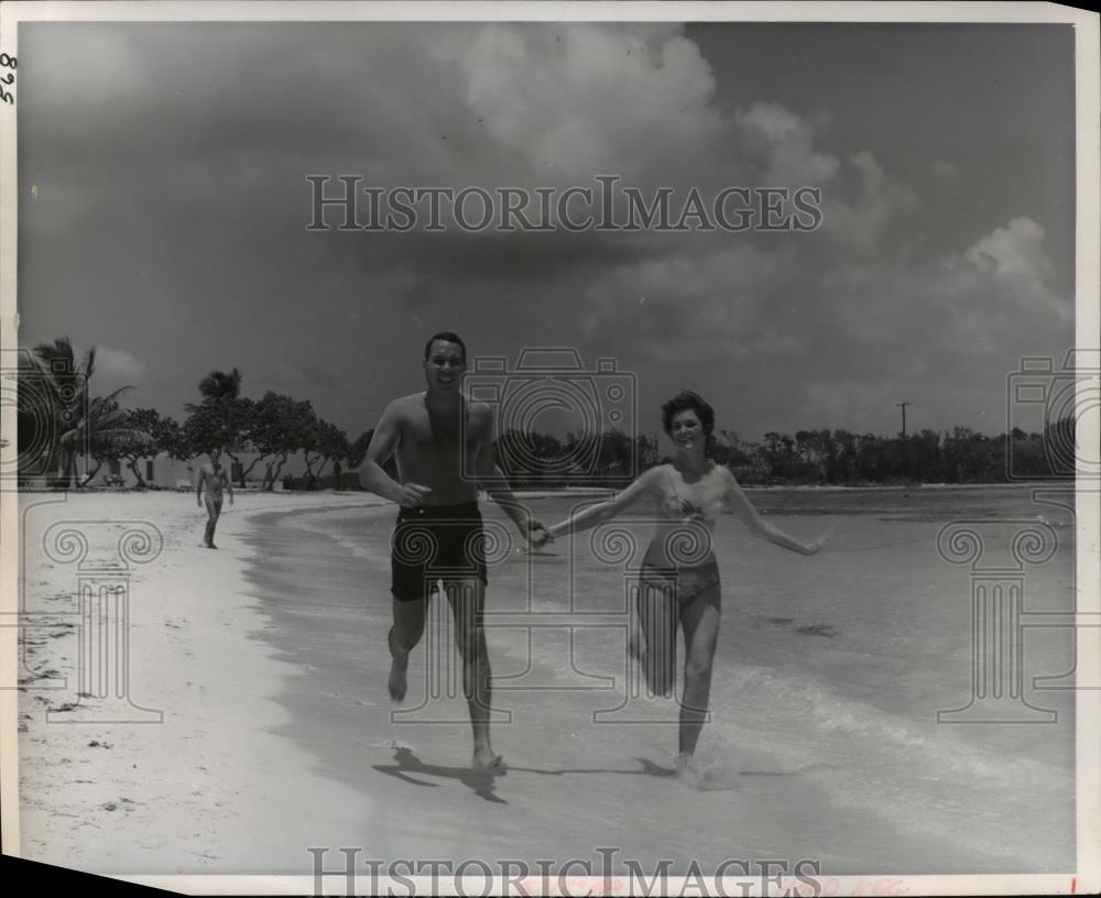 1967 Press Photo Couple racing along the sands of Bluebeard&#39;s Beach Club - Historic Images